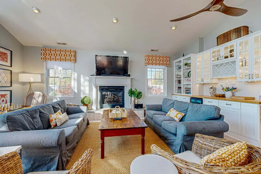 Living room with seating, a fireplace, and built-in shelving.