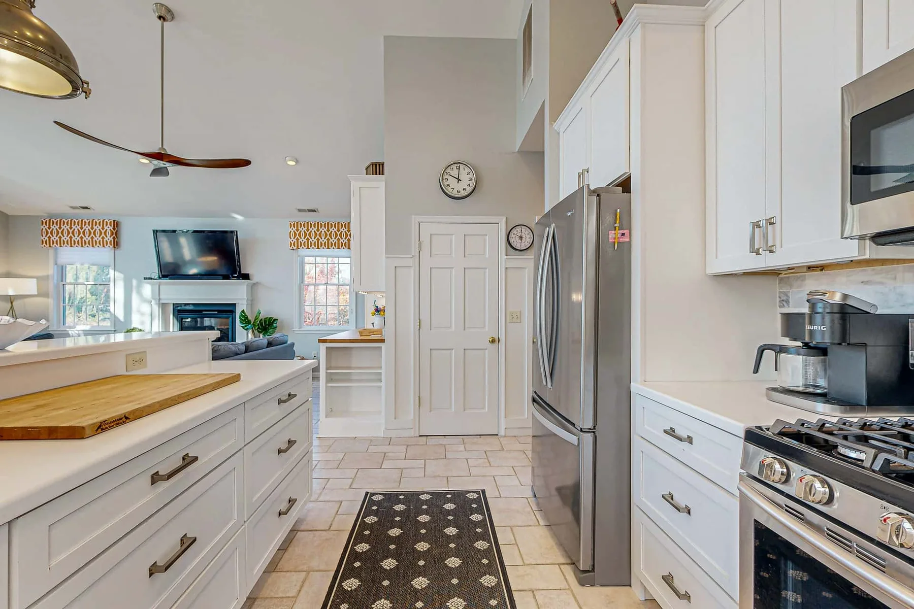 A bright kitchen with white cabinets, stainless steel appliances, and a central island.