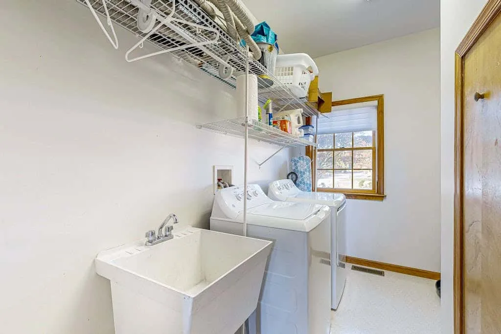 A laundry room with a utility sink, washing machine, and dryer.