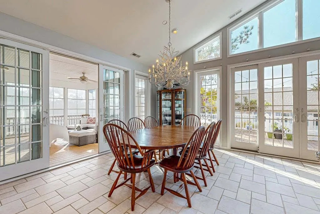 A bright dining room with a wooden table and large windows.