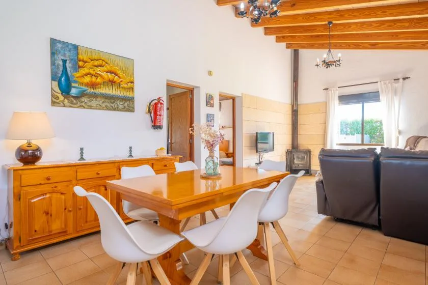 A dining area with a wooden table and seating beside a living area.