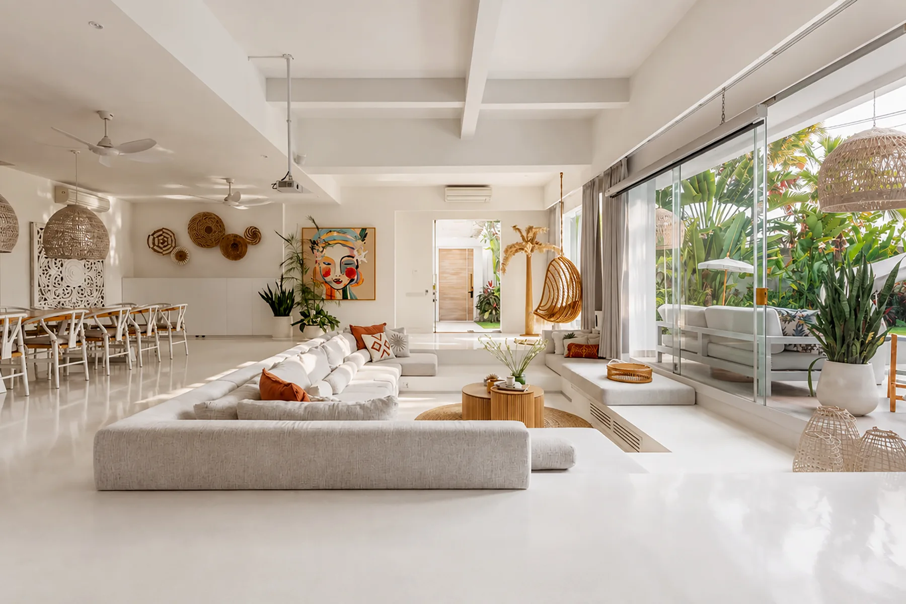 A bright open-plan living and dining area with seating beside large windows.