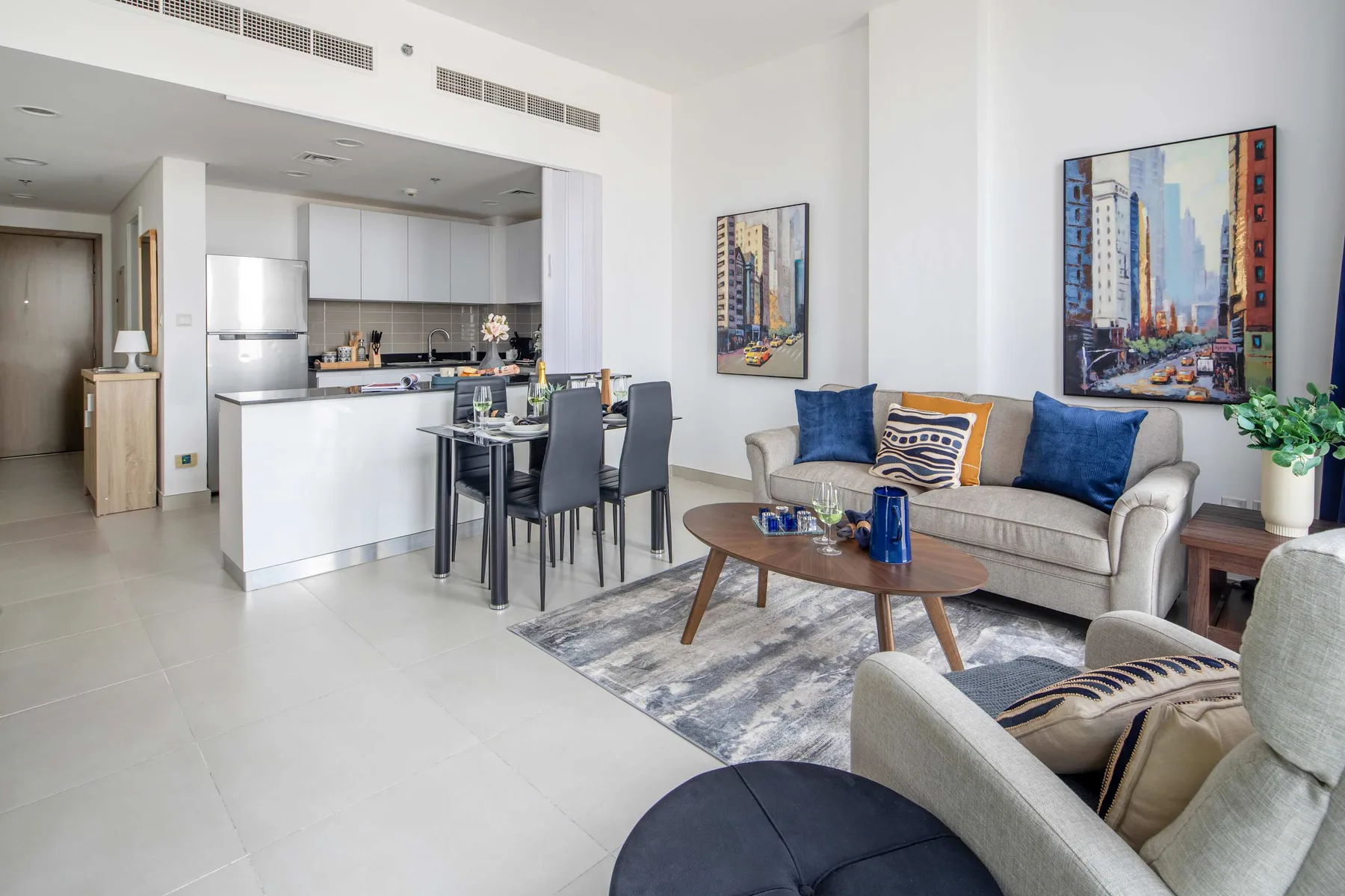 Una sala luminosa con asientos, una mesa de centro y una cocina abierta.