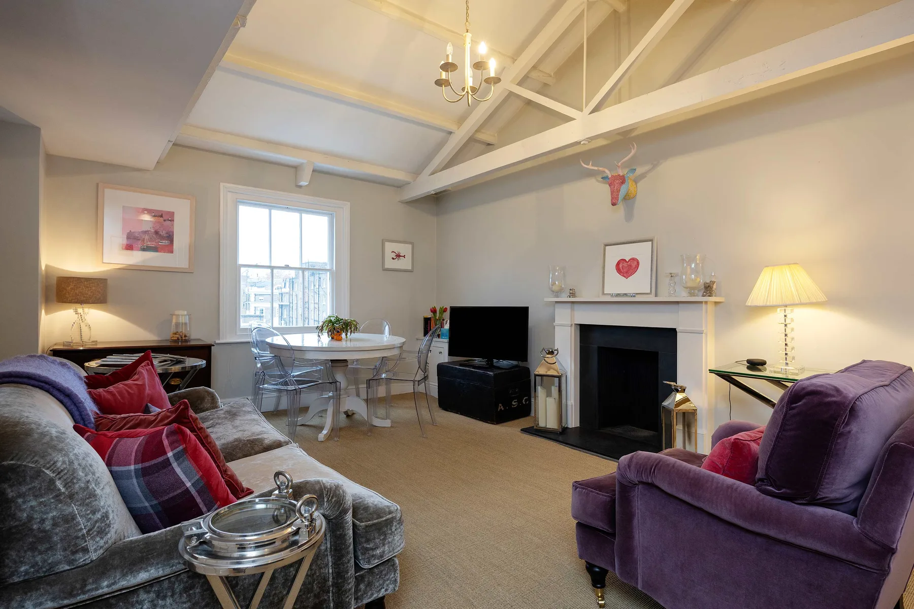 A living room with seating, a dining table, and a fireplace.