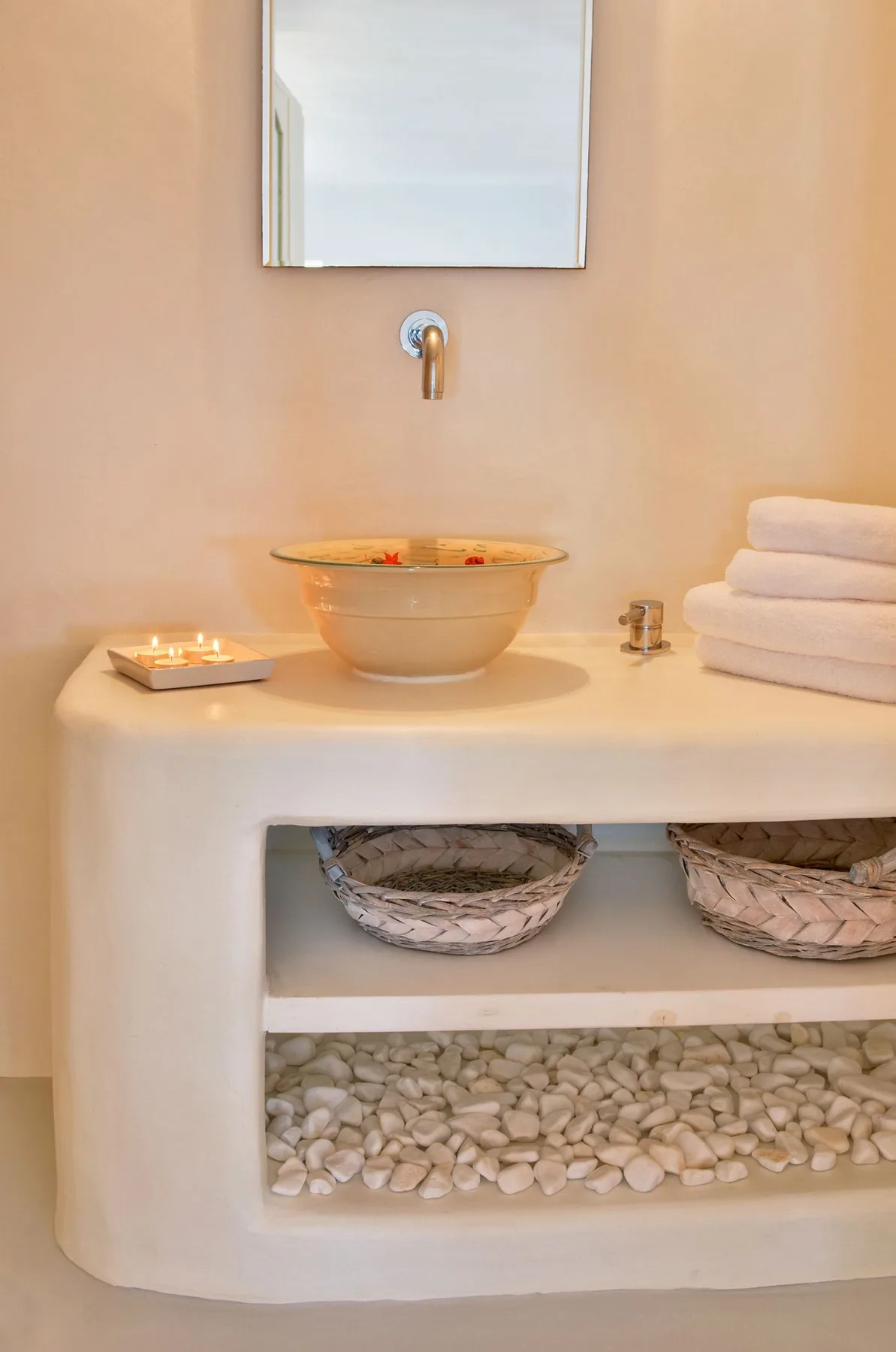 A bathroom vanity with a vessel sink, mirror, and folded towels.
