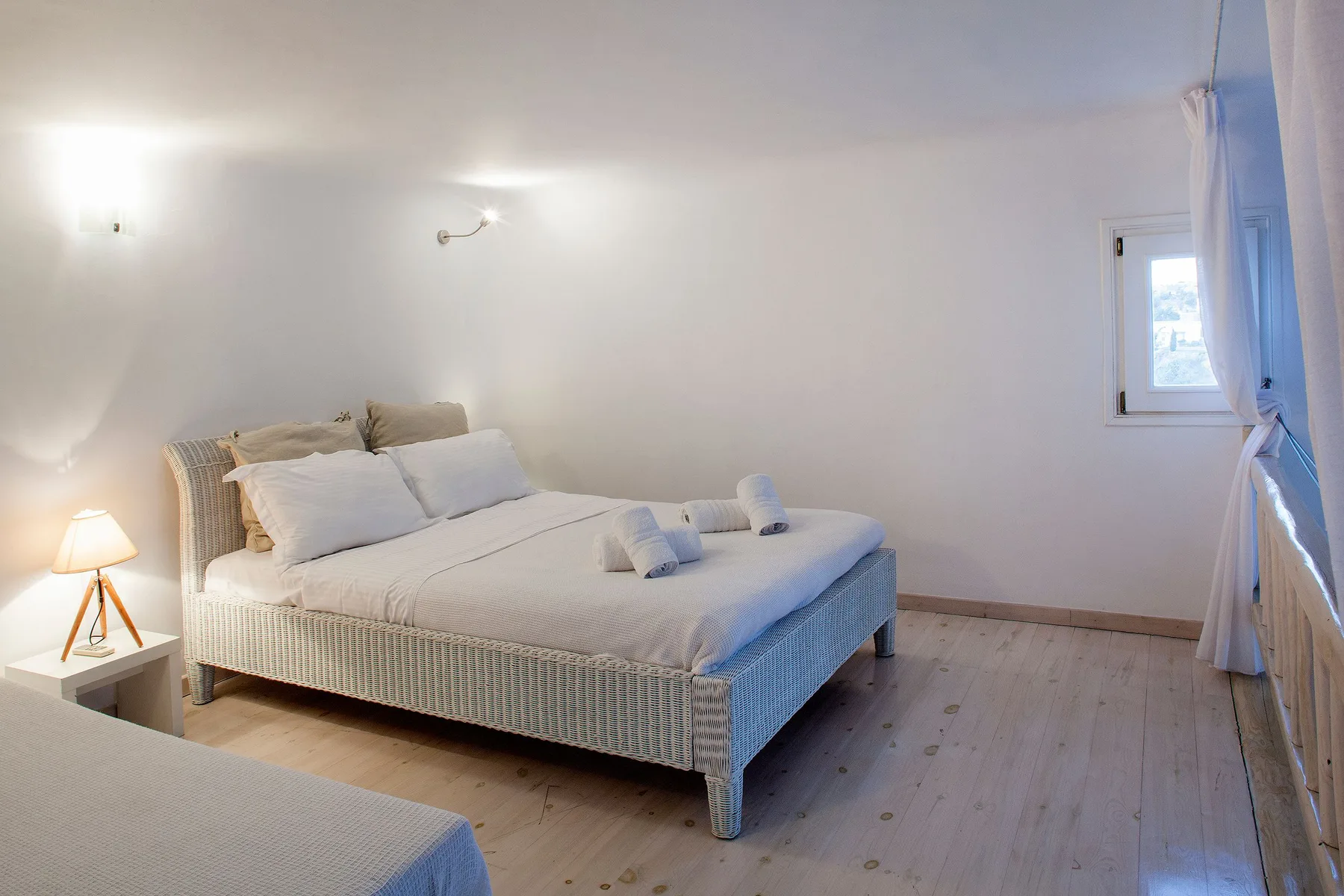 A bright bedroom with a bed and a window.