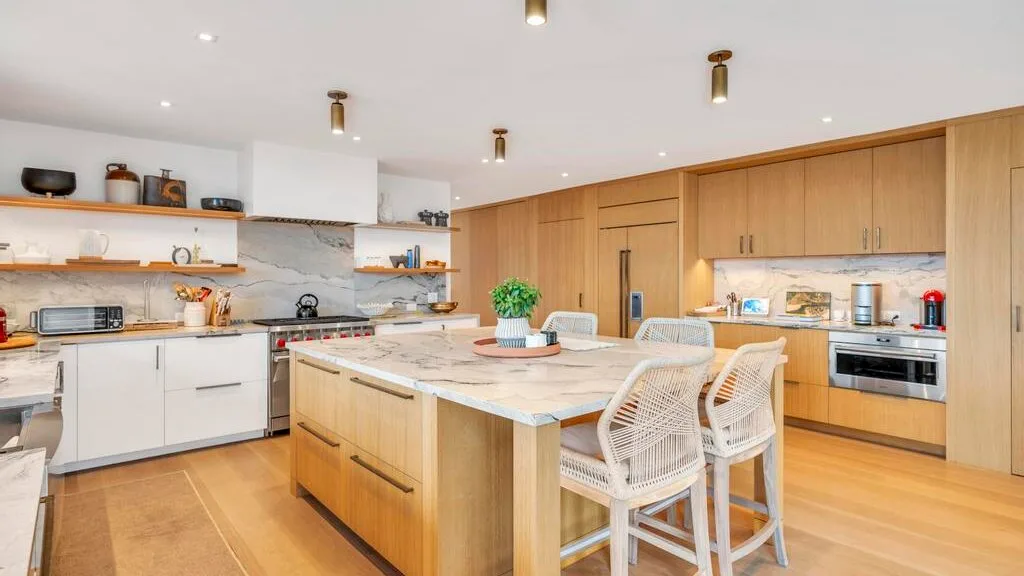 Una cocina amplia con una isla central y gabinetes de madera clara.