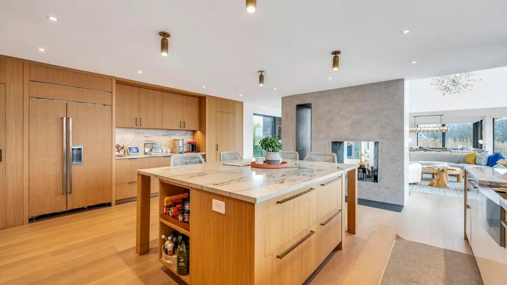 Una cocina luminosa con una isla central grande y gabinetes de madera.