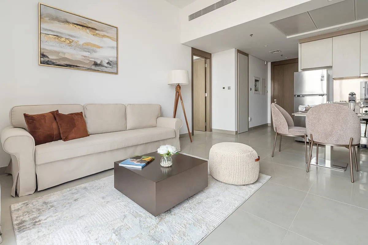A living room with a sofa, coffee table, and open kitchen area.