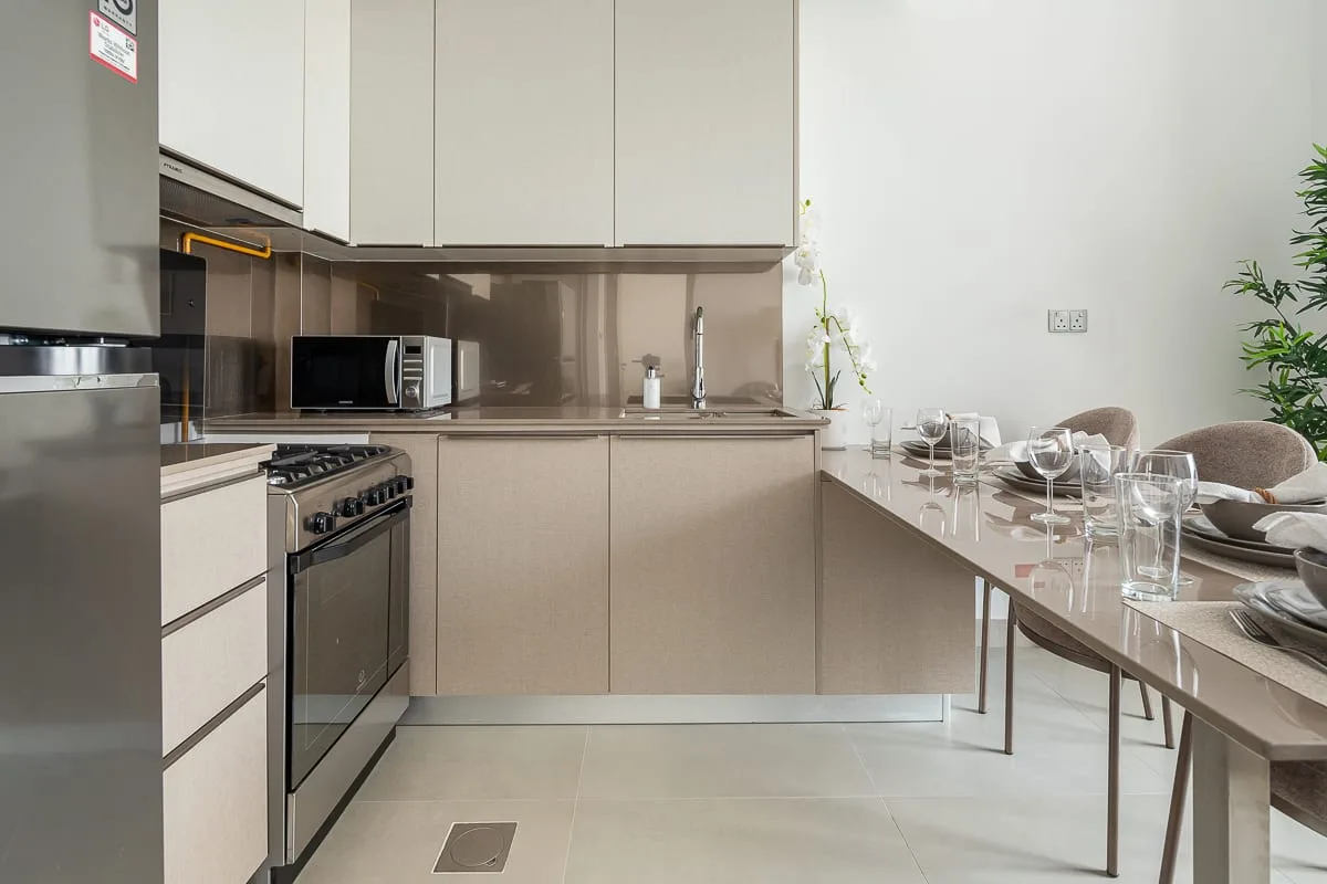 Una cocina moderna con una mesa de comedor puesta con platos y vasos.