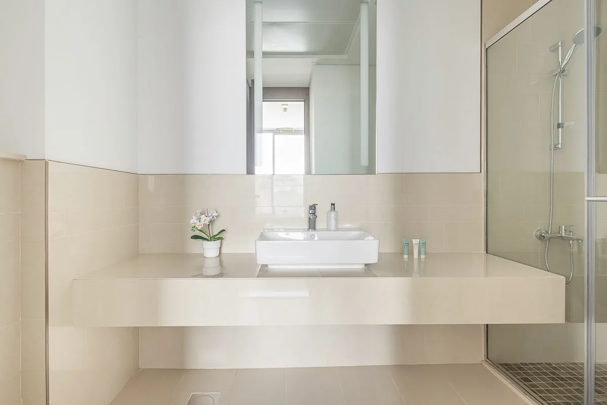 A bright bathroom with a wide sink beneath a large mirror.