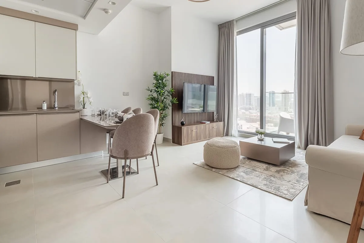 A bright open-plan living and dining area with a kitchen and large windows.