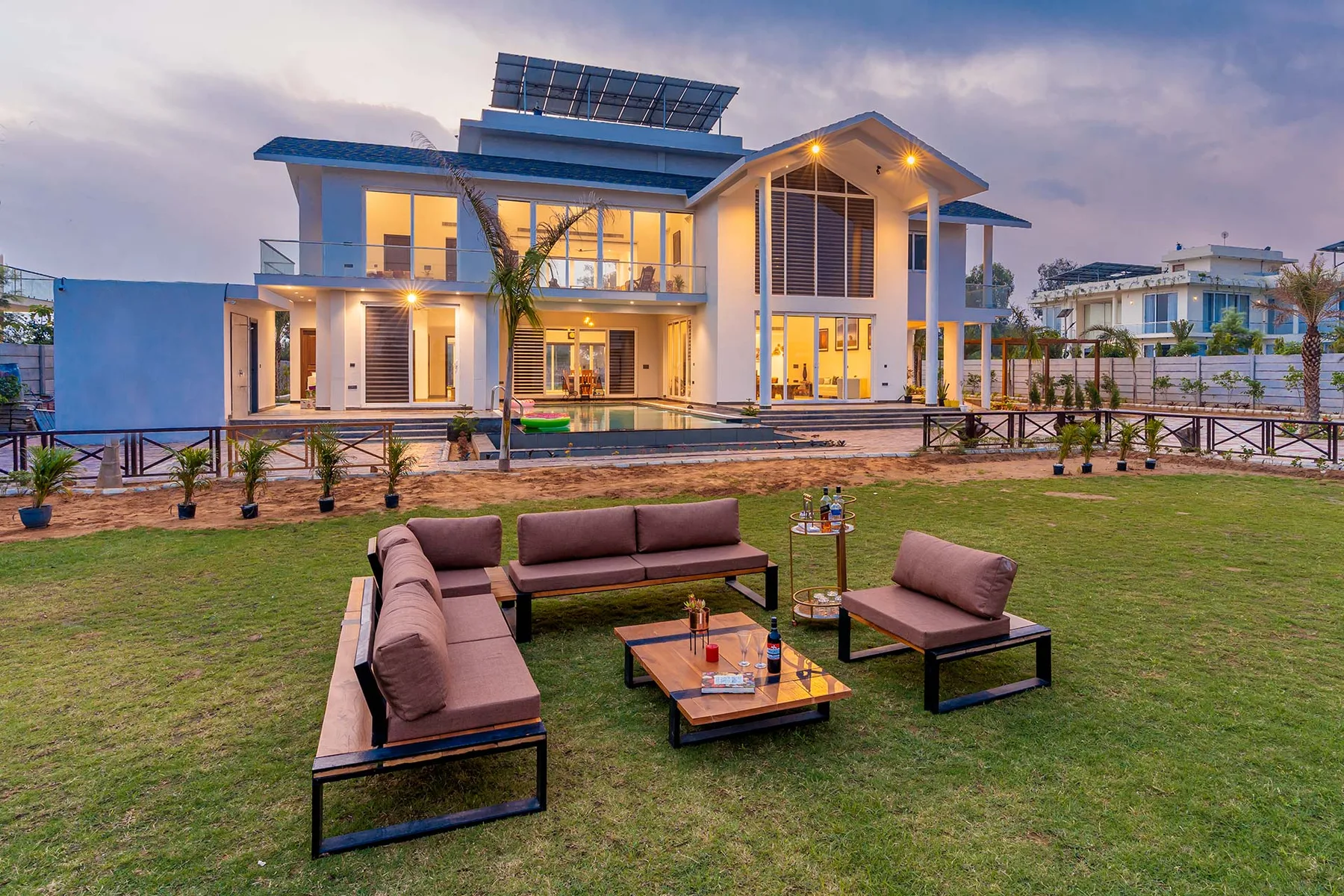Una casa moderna da a una zona de estar al aire libre sobre el césped.