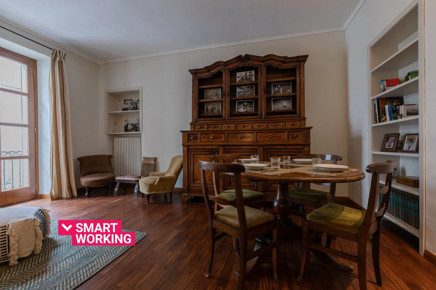 Comedor con una mesa de madera y sillas junto a un gran mueble expositor.