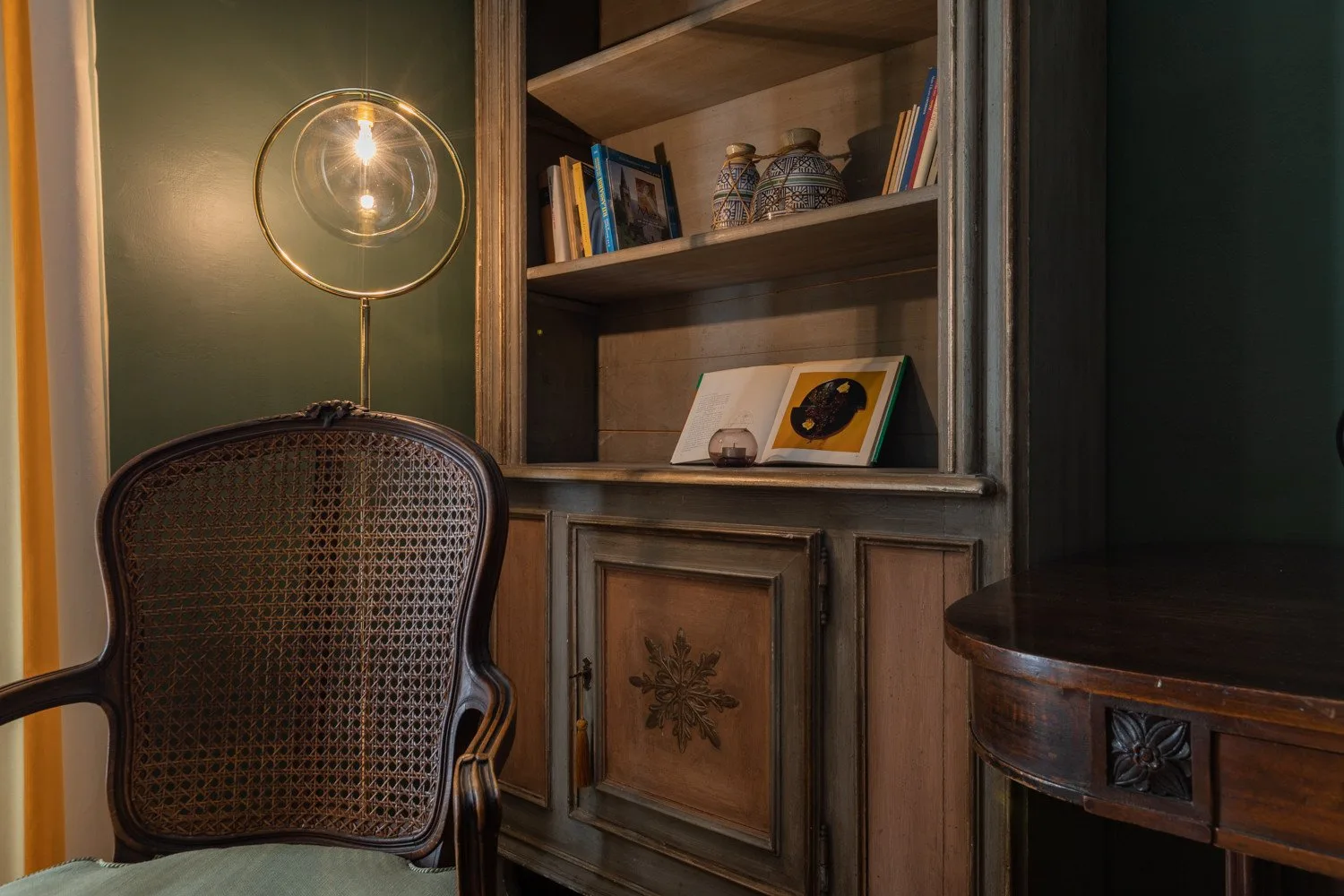 Un acogedor rincón de lectura cuenta con una estantería empotrada con libros y objetos decorativos.