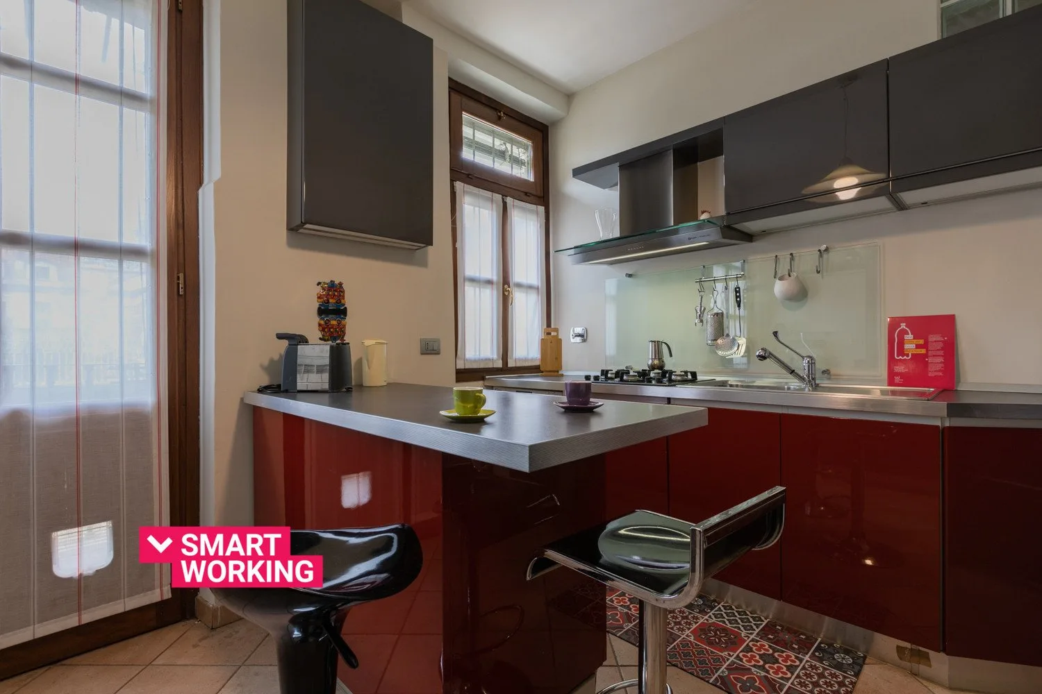 Una cocina con una encimera central y gabinetes superiores oscuros.
