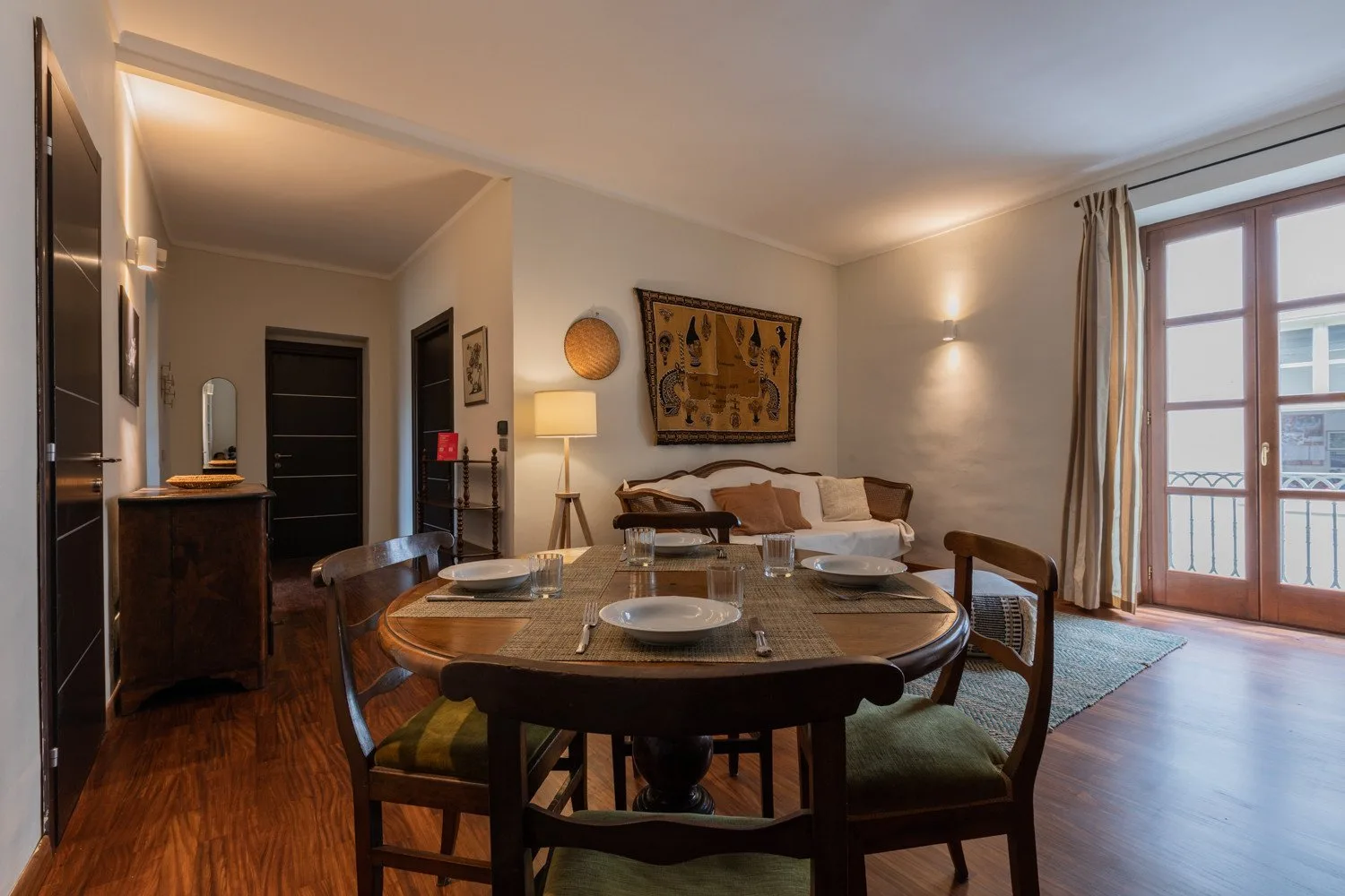 Un comedor con una mesa redonda y asientos junto a una sala de estar.