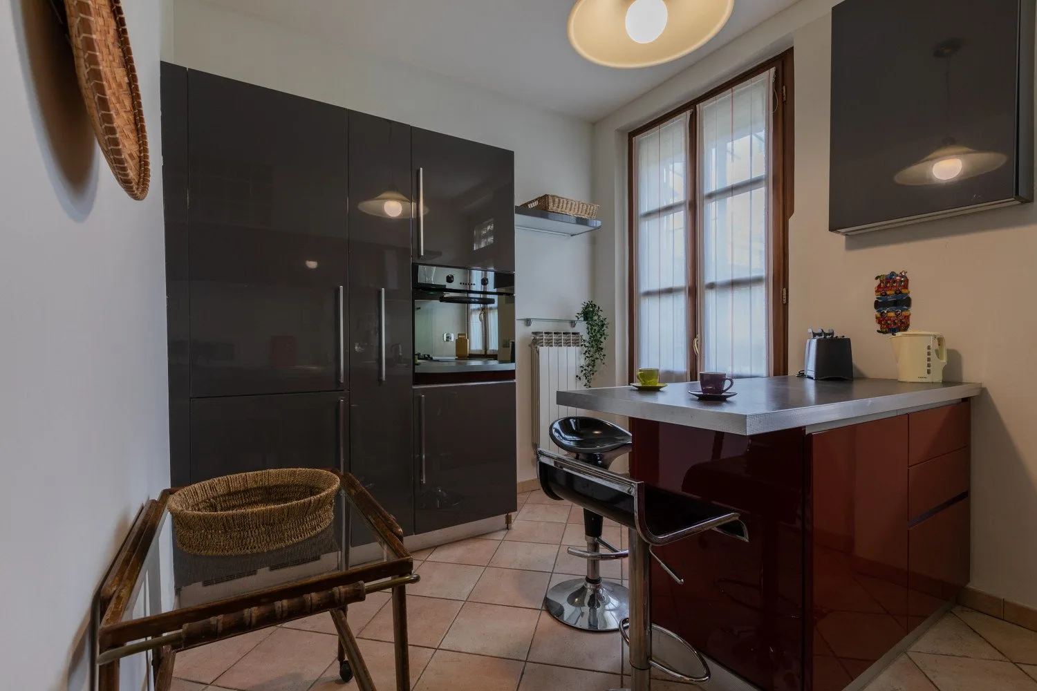 Una cocina moderna con gabinetes oscuros, un horno y una isla central.