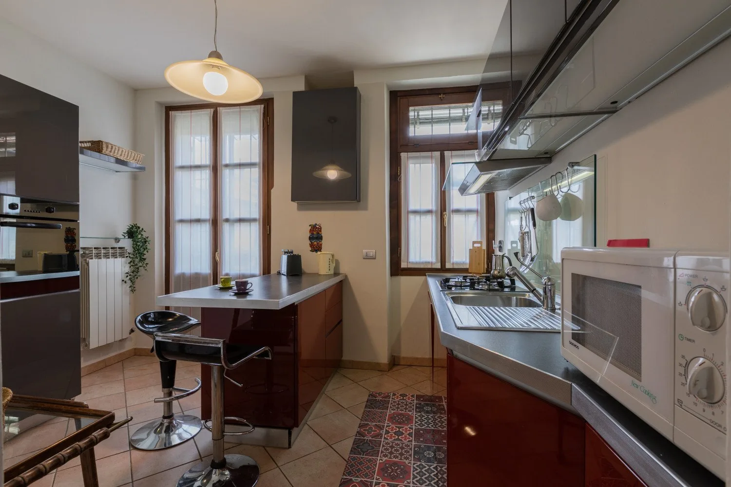 Una cocina con una barra central, una estufa y electrodomésticos sobre la encimera.