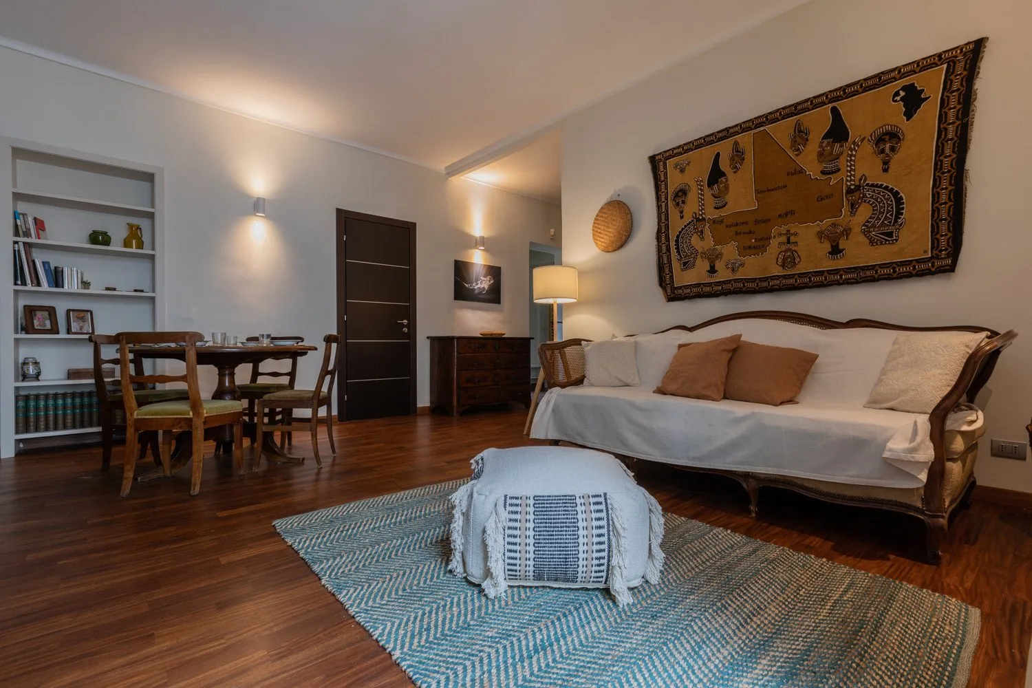 Una acogedora sala de estar con asientos, una mesa de comedor y una alfombra estampada.