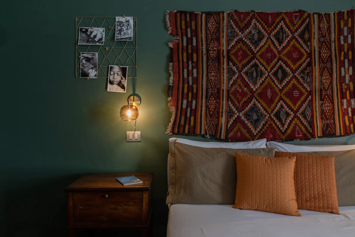 Un dormitorio con una cama bajo tapices coloridos con diseños.