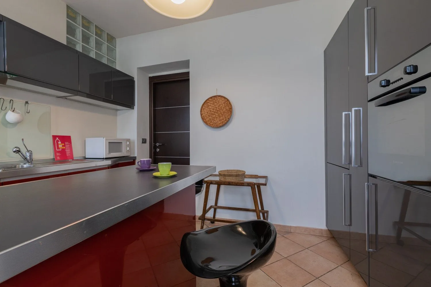 Cocina moderna con una encimera larga, armarios y una pequeña mesa de comedor.