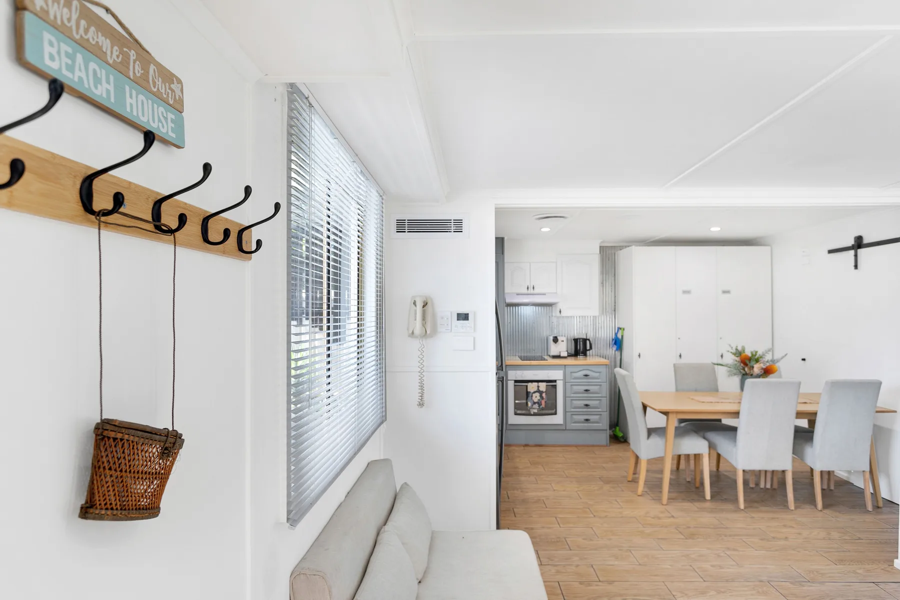 Una luminosa sala de estar y comedor diáfanos con la cocina al fondo.