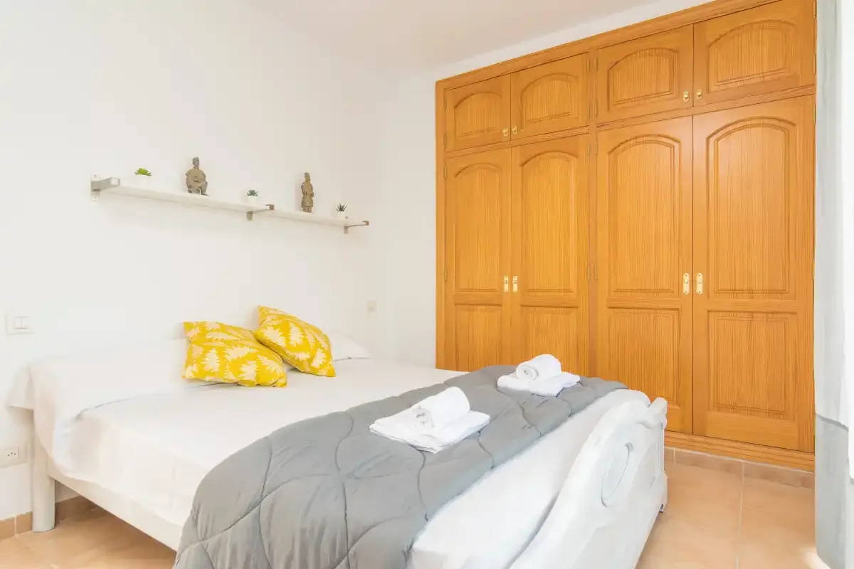 Un dormitorio con una cama y un armario grande de madera.