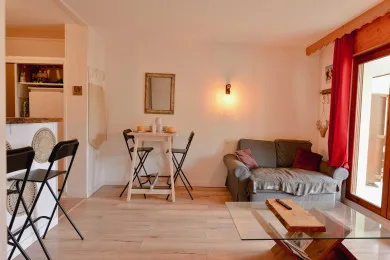 A living and dining area with a small table, seating, and a glass coffee table.
