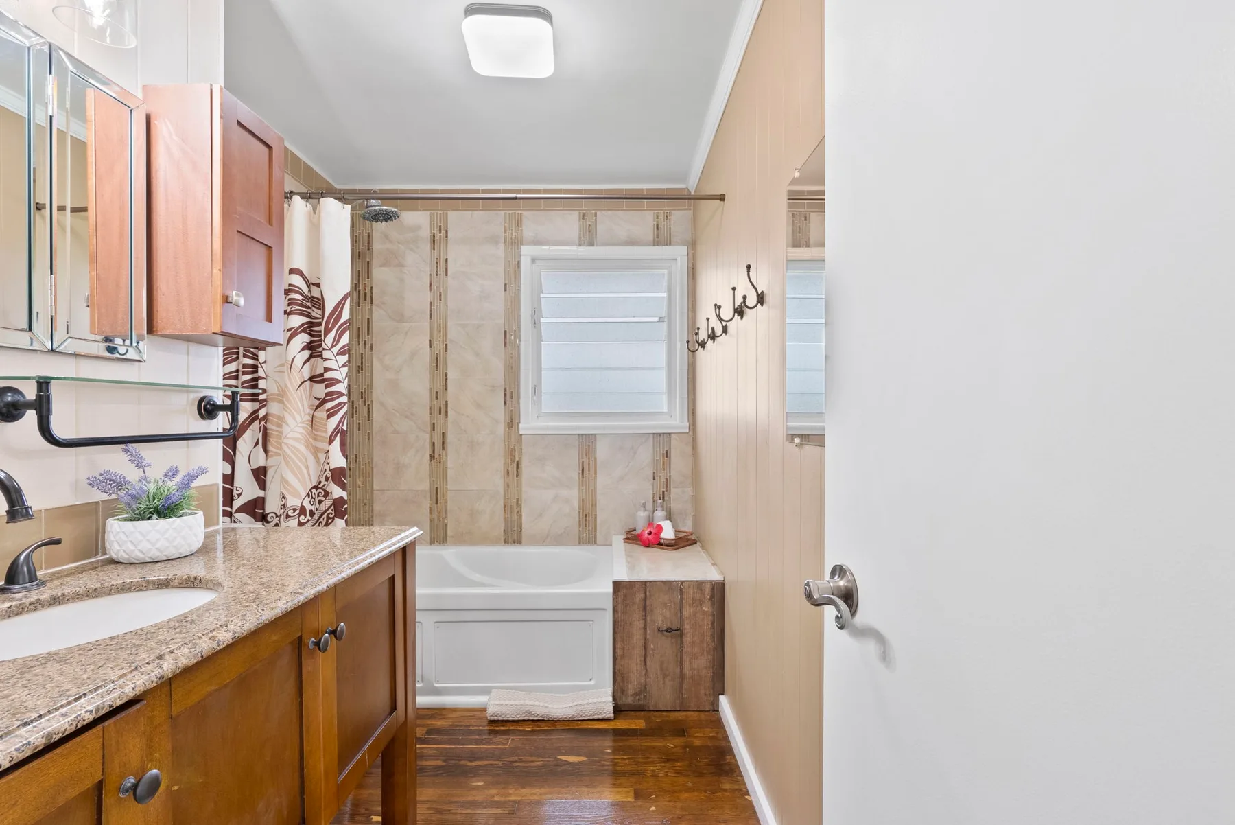 Un baño con bañera, lavabo y tocador de acabado en madera.