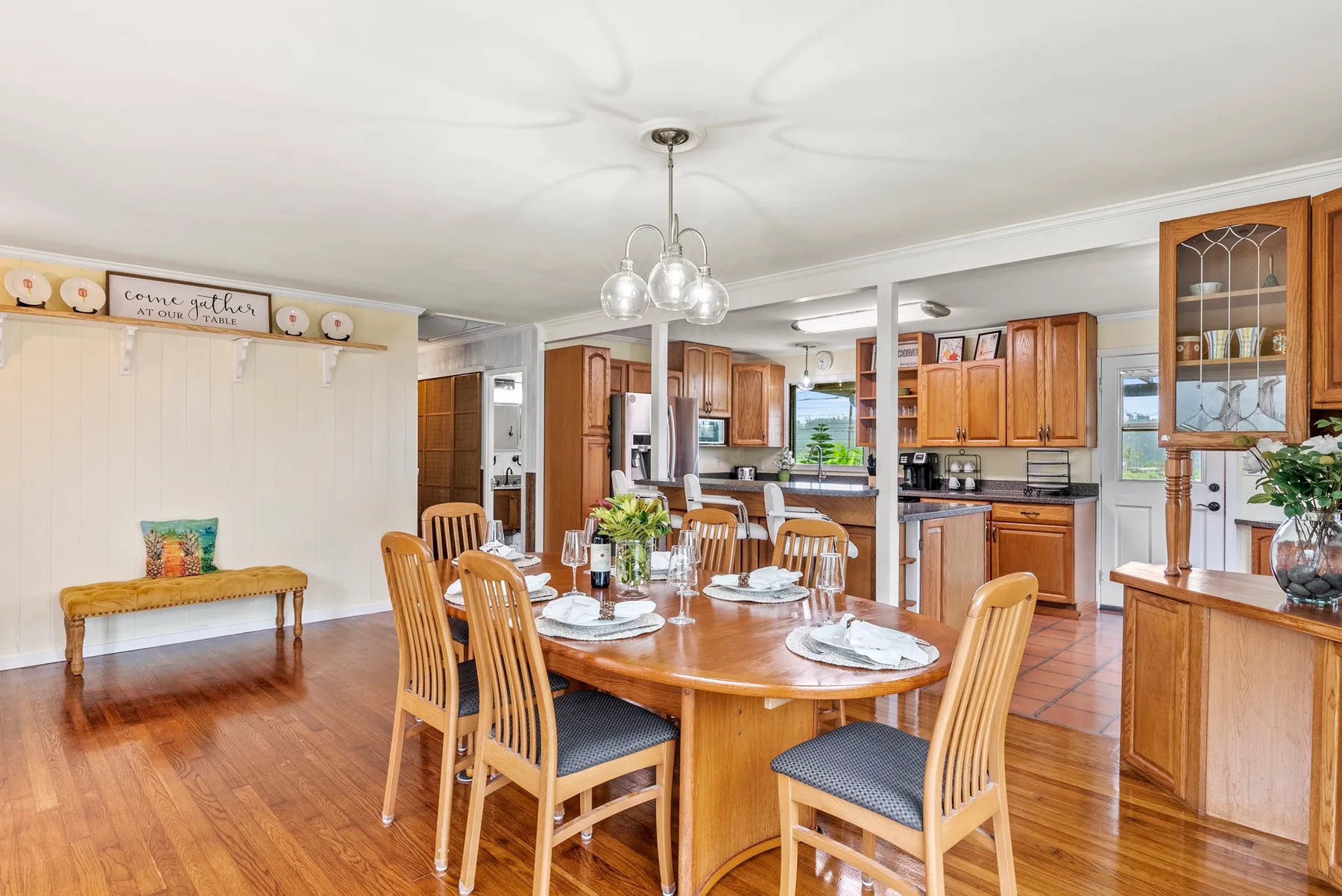 Un comedor con una mesa y sillas de madera junto a una cocina.
