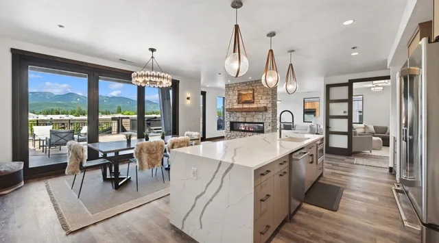 An open-plan kitchen and dining area with a large island and glass doors.
