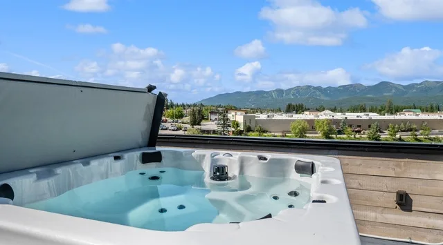 Outdoor hot tub on a rooftop deck with mountain views.