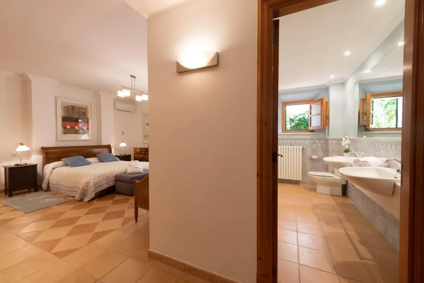 A bedroom and adjoining bathroom are visible through an open doorway.