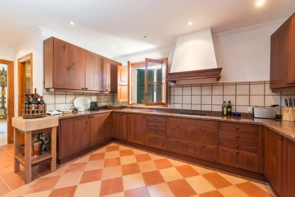 A spacious kitchen with wooden cabinets and tiled flooring.