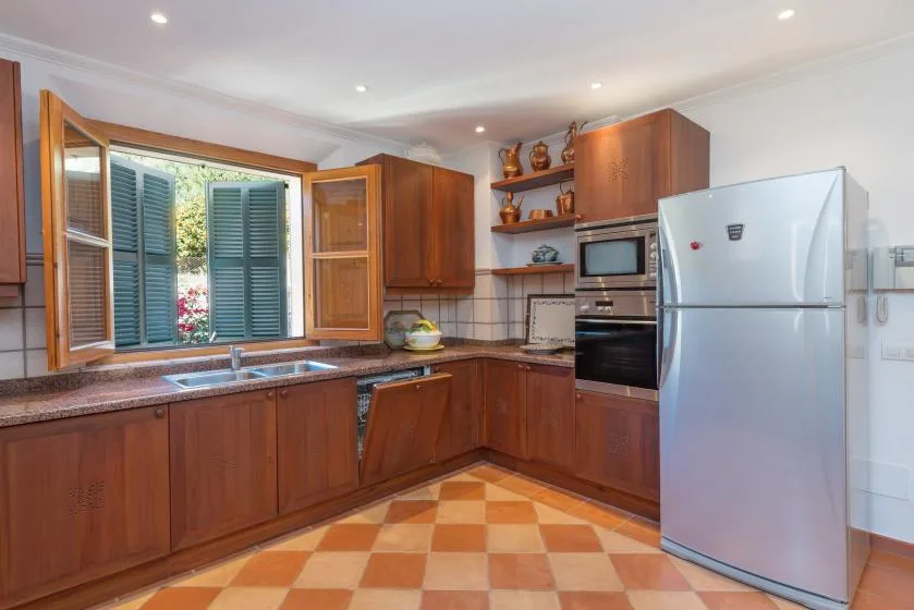 A kitchen with wooden cabinets, a countertop, and a refrigerator.
