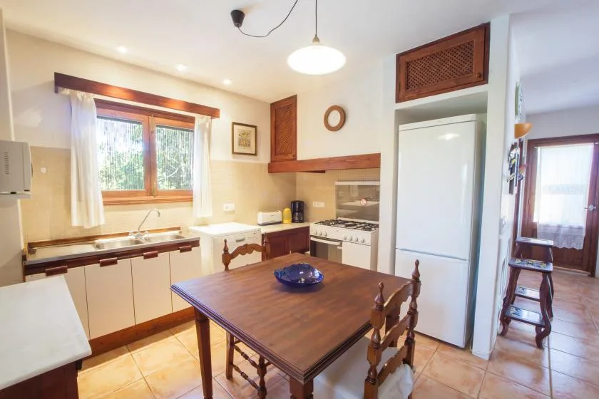 A bright kitchen and dining area with wooden cabinets and a table.