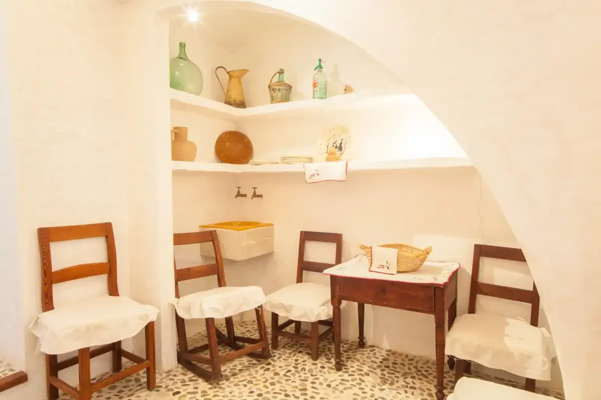 A small dining area with wooden seating and a table beneath built-in shelves.