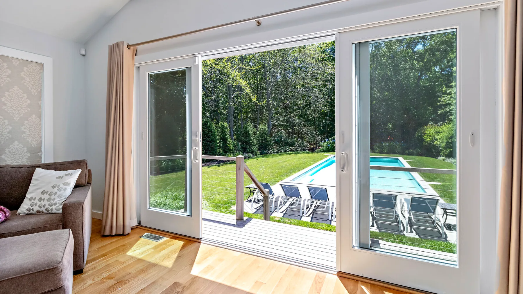 Una sala luminosa se abre a un patio con piscina y jardín.