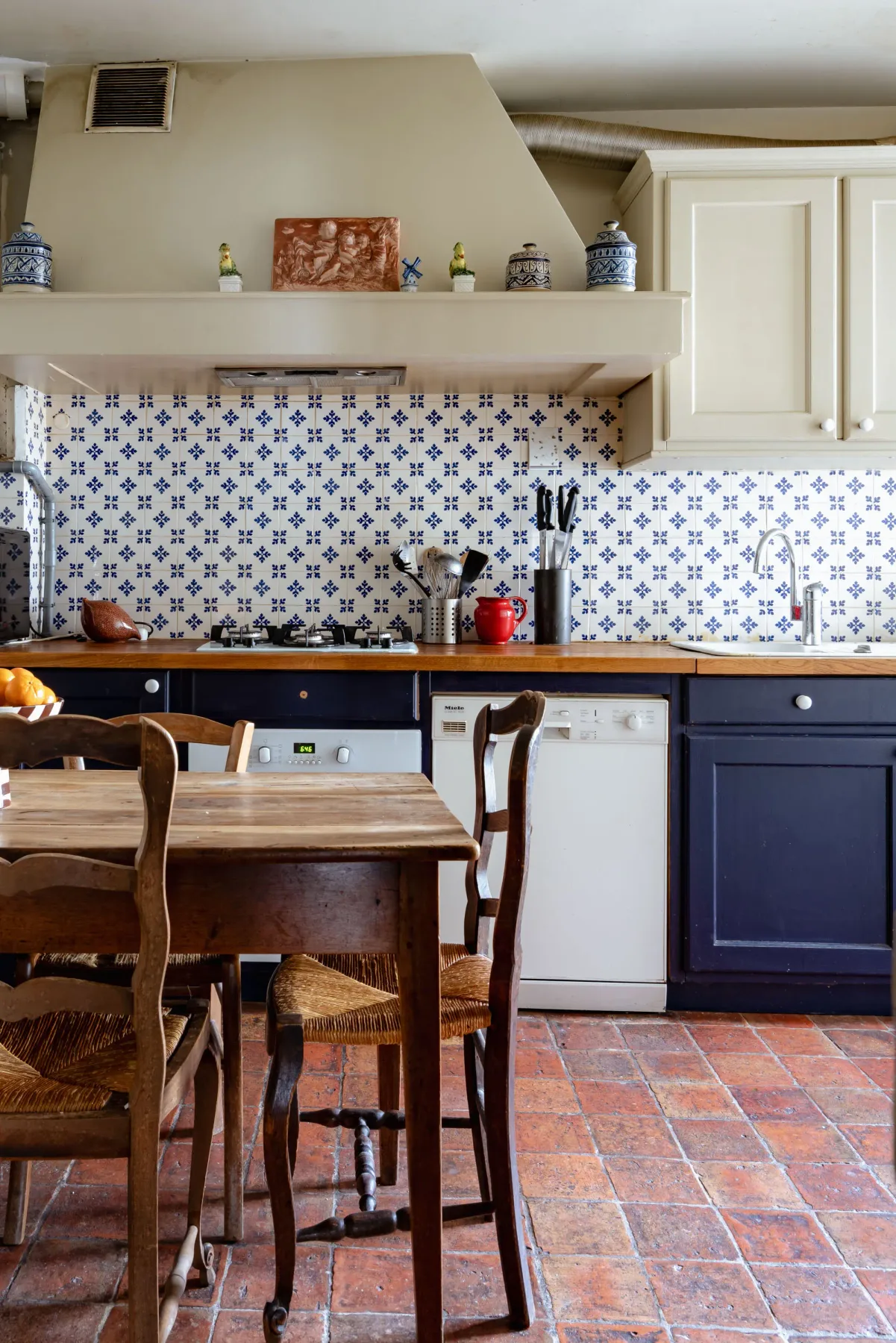 A kitchen and dining area with blue cabinetry and a wooden table.