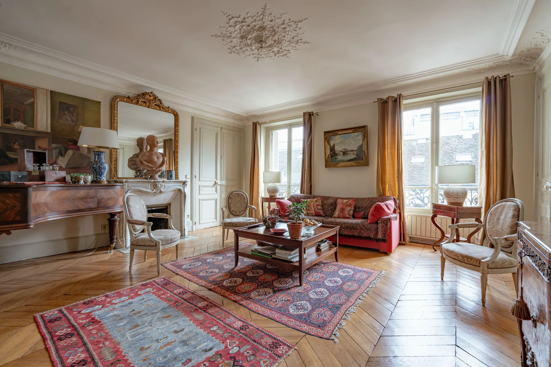 A living room with seating, a coffee table, and patterned rugs.