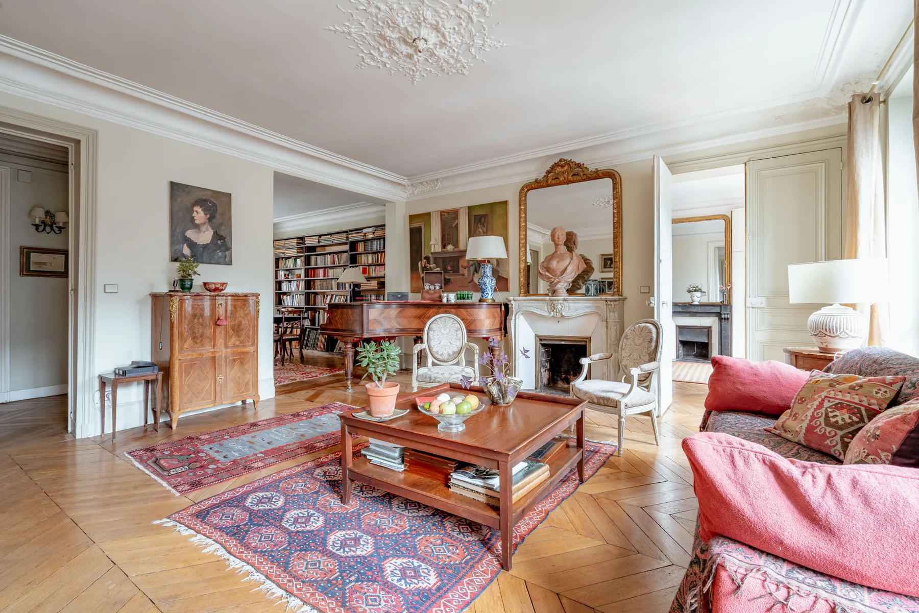 A bright living room with a fireplace, seating, and a wooden coffee table.