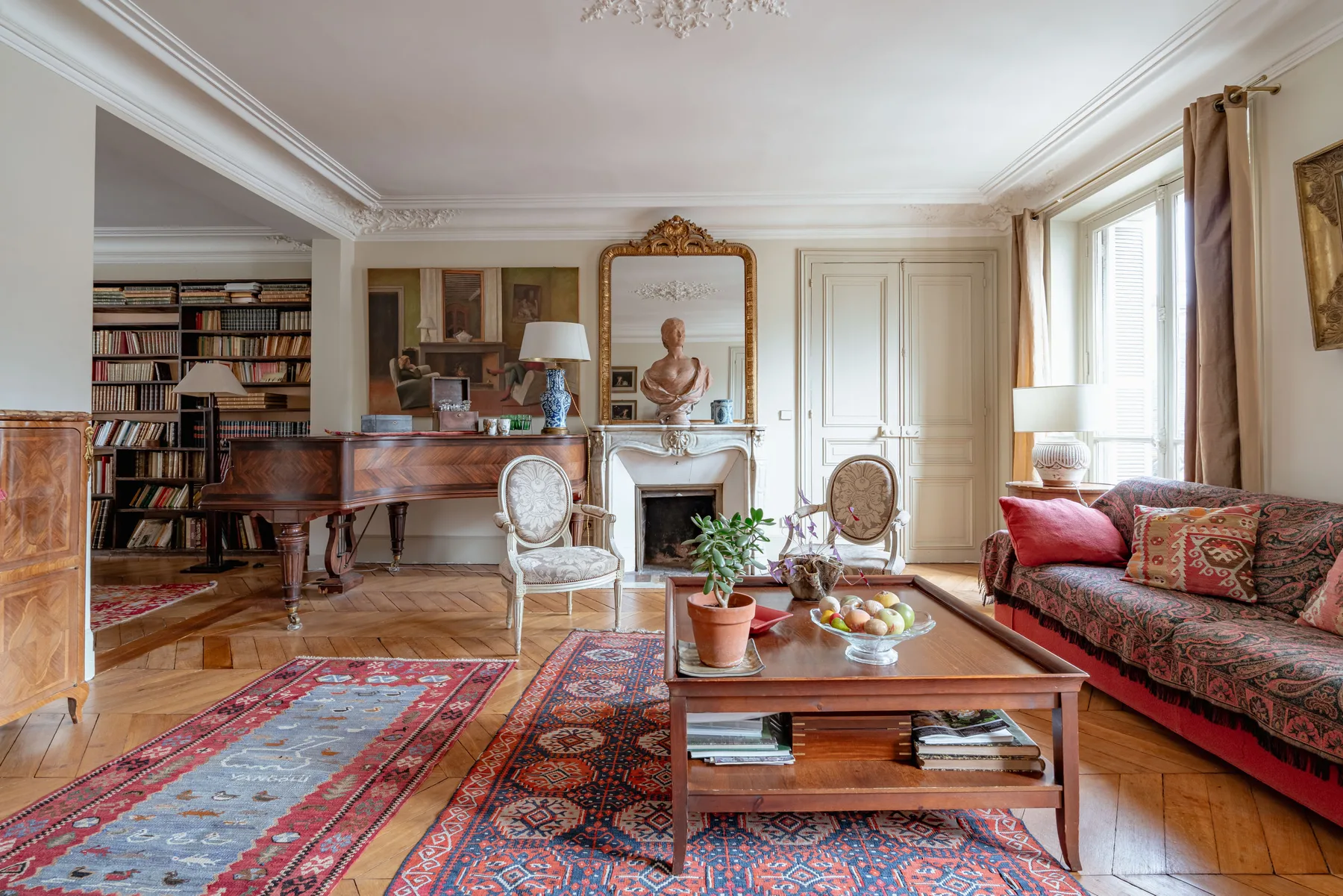 An elegant living room with seating, a coffee table, and a fireplace.
