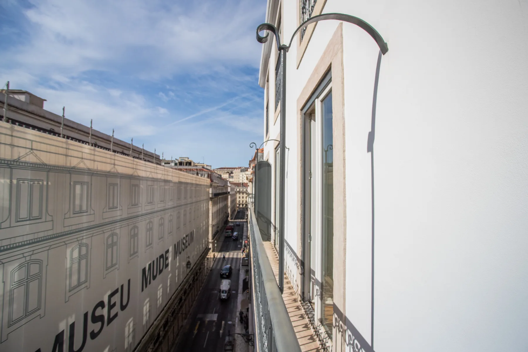 A narrow street runs between historic buildings beneath a blue sky.