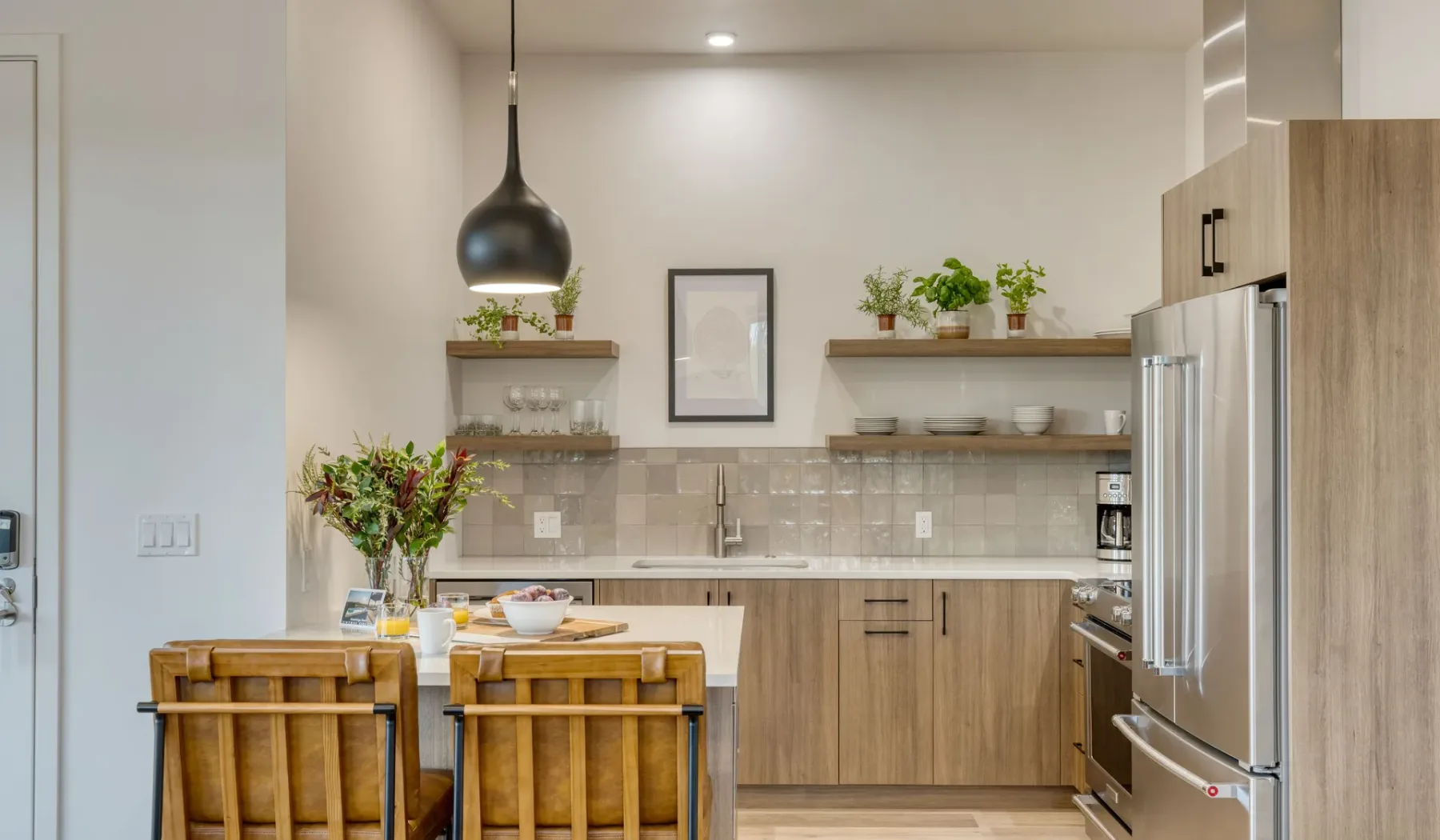 Una cocina con mesa de comedor, asientos de madera y electrodomésticos de acero inoxidable.