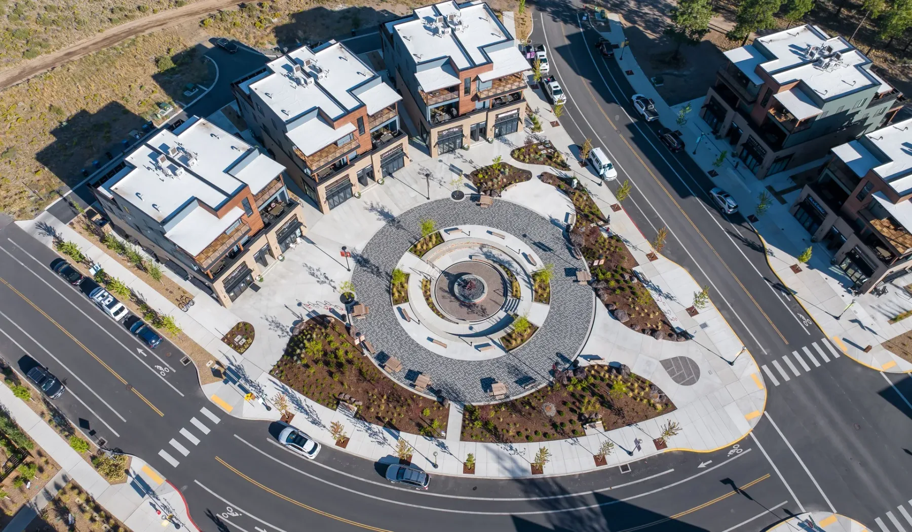 An aerial view of a circular plaza surrounded by modern buildings and roads.