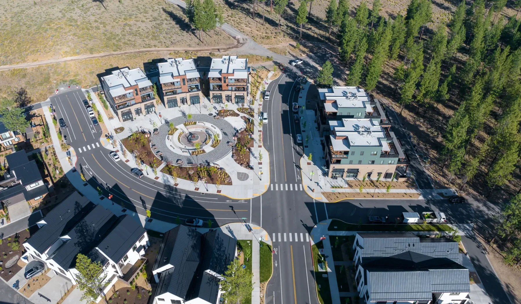 An aerial view of a residential complex around a circular landscaped courtyard.