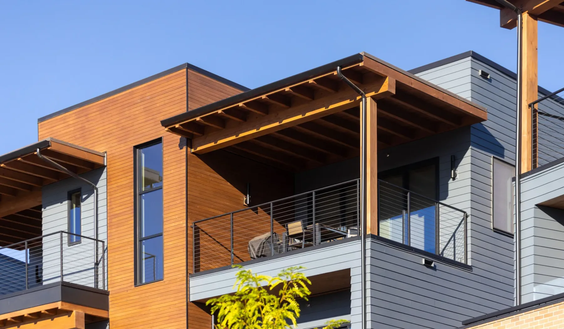 A modern building exterior with wood-toned siding and balconies.
