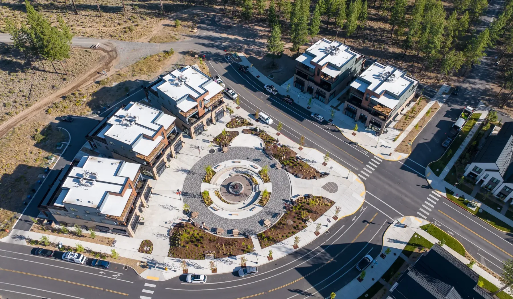 Aerial view of a modern building complex around a circular landscaped plaza.