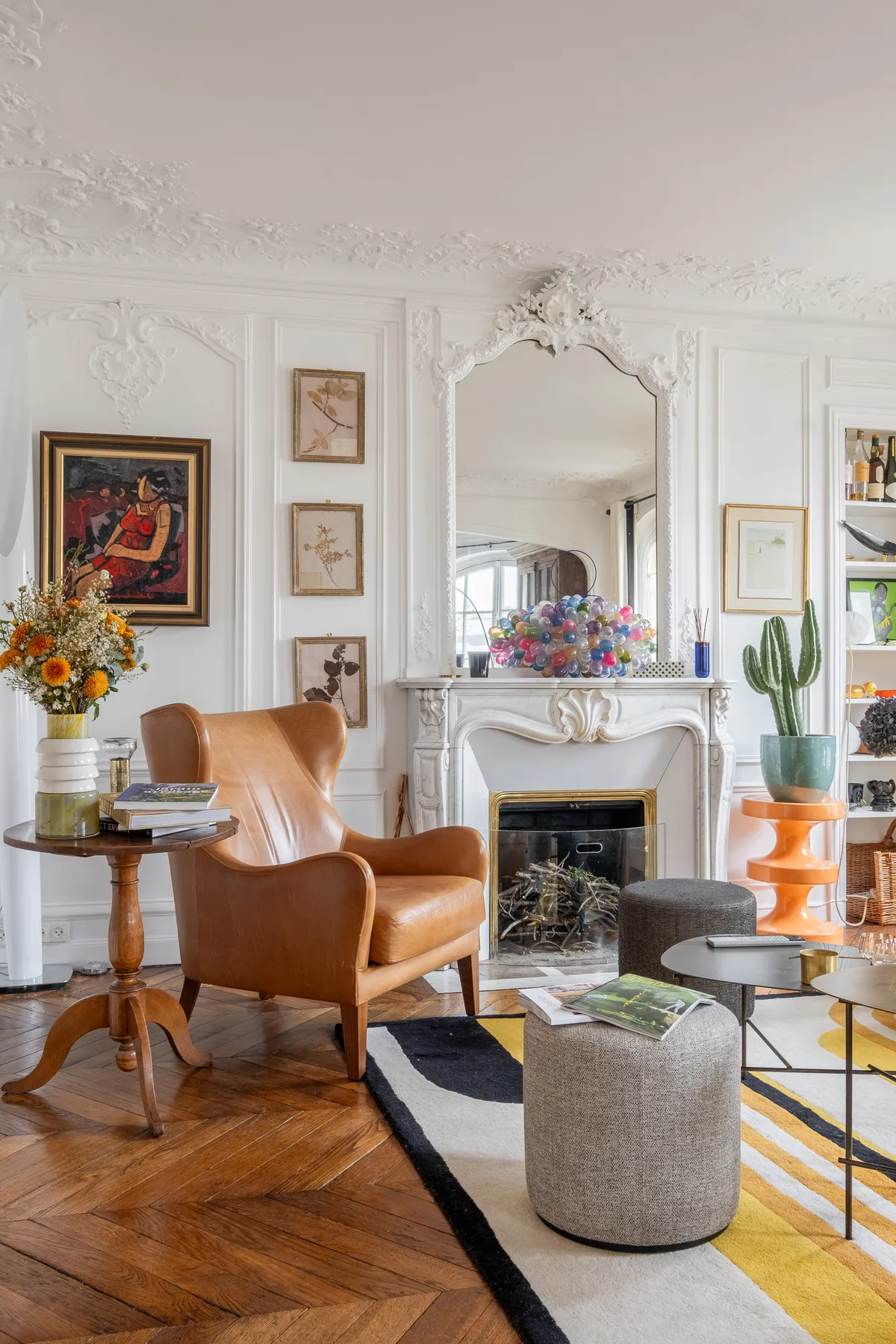 An ornate living room with seating arranged around a fireplace.